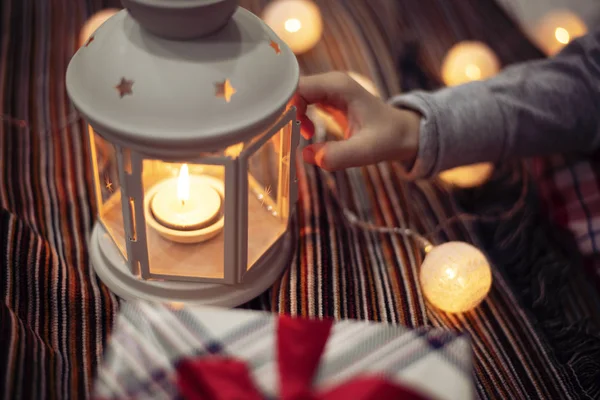 Merry Christmas and Happy Holidays!  Xmas winter holidays concept. Child girl hand holding a candlestick. Christmas decoration, festive lights