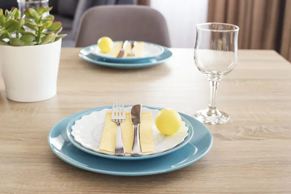 Hermoso ajuste de mesa de Pascua con decoraciones. Placas azules en alfombras de alimentación amarillas. Huevos pintados de Pascua amarillos —  Fotos de Stock