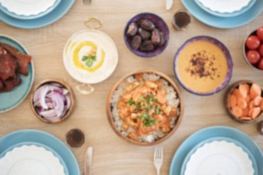 Evdeki iftar yemek masasının bulanık arkaplanı. Ramazan için akşam yemeği. Arap mutfağı. Orta Doğu Geleneksel Yemeği. Mısır Doğu Yemekleri 'nin çeşitli ürünleri. Mavi Tablo Ayarları.