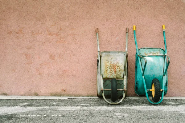 Wheelbarrows leaning against wall — Stock Photo, Image