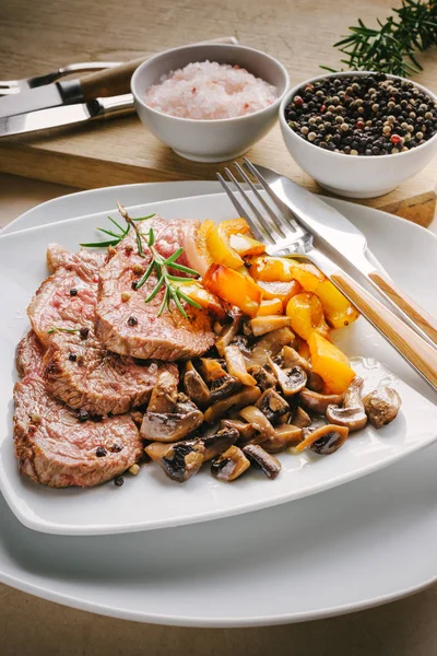 Fatias Carne Grelhadas Com Cogumelos Champignon Pimentas Amarelas Placa Branca — Fotografia de Stock