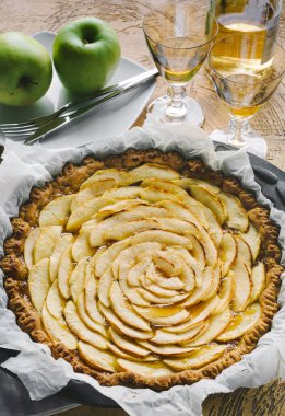 Ahşap arka planda kek tepsisinde ev yapımı elmalı tart.