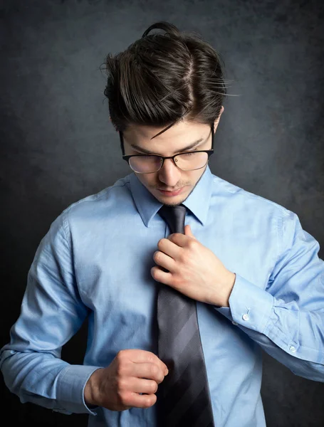 Retrato Joven Empresario Con Camisa Azul Arreglando Corbata Mirando Hacia —  Fotos de Stock