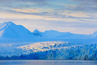 Land of ice. Travelling in Arctic Norway. White snowy mountain, blue glacier Svalbard, Norway. Ice in ocean. Iceberg in North pole. Blue sky with ice floe. Beautiful landscape. Cold sea  water.  clipart