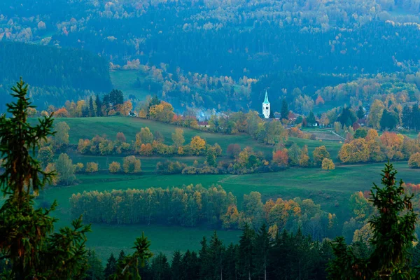 Sumava, Czech Republic, evening in Kasperske hory with church,. Cold day in Sumava National park, hills and villages in orange trees, misty view on czech landscape, autumn scene. — Stockfoto