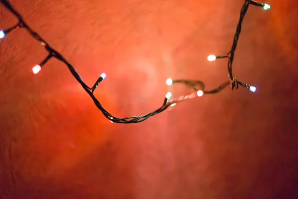 Christmas lights on red background, shallow focus — Stock Photo, Image