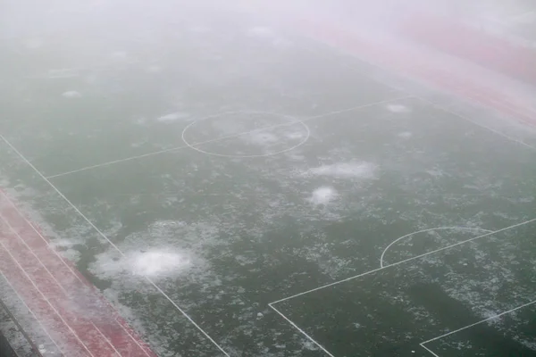 Fotbalové hřiště v mlze a tání sněhu Stock Snímky