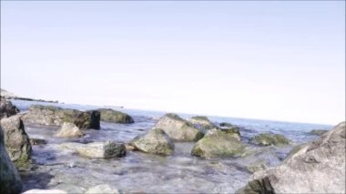 Dalgalar çakıl taşı plajını yıkıyor. Deniz dalgaları çakıl taşlı plajları yıkar 