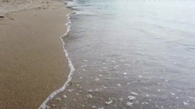 Çakıl taşlarında dalgalar kopuyor. Deniz sörfü. Dalgalar kıyı çakıl taşında ilerliyor. Yaz günü deniz ve sahil tatili konsepti 