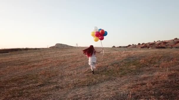 Mutlu Neşeli Kız Balonlarla Yazın Gün Batımında Doğada Çayırlarda Koşuyor — Stok video