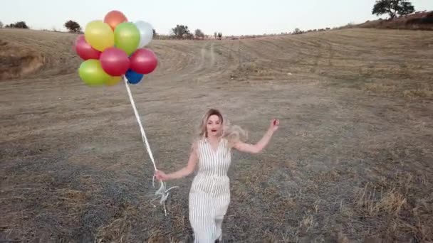 Ευτυχισμένο Χαρούμενο Κορίτσι Πολύχρωμα Μπαλόνια Τρέχει Όλη Λιβάδι Στο Ηλιοβασίλεμα — Αρχείο Βίντεο