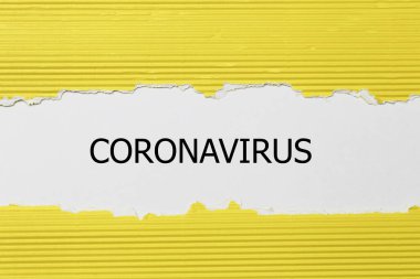 Yırtık kağıdın arkasında CORONAVIRUS kelimesi beliriyor