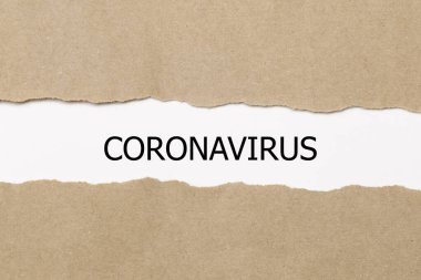 Yırtık kağıdın arkasında CORONAVIRUS kelimesi beliriyor