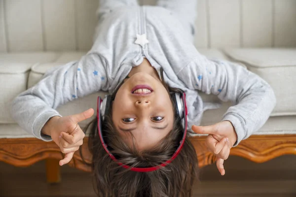 little girl with headphones at home. child girl listening to music.