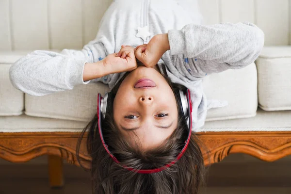 ittle girl with headphones at home. child girl listening to music.