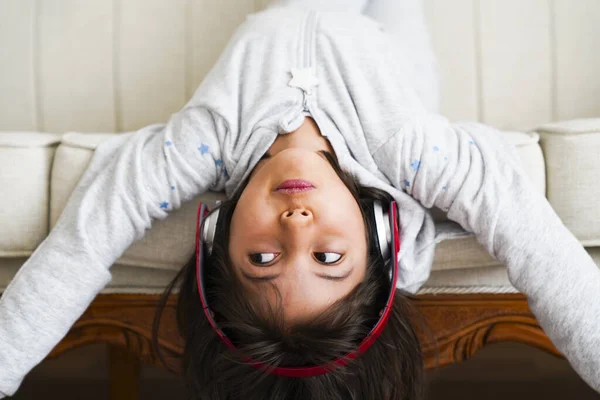 little girl with headphones at home. child girl listening to music.