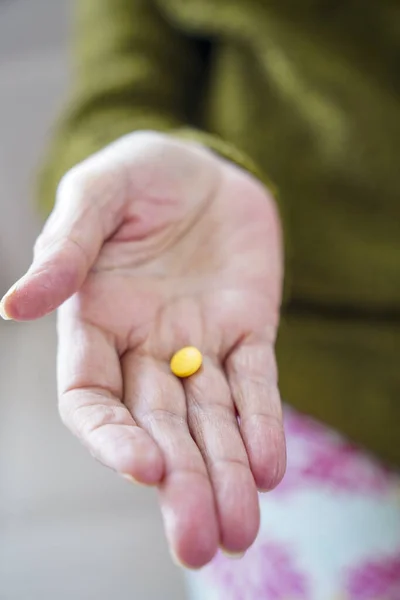 pills in a Senior's hands. Painful old age. Caring for the health of the elderly.