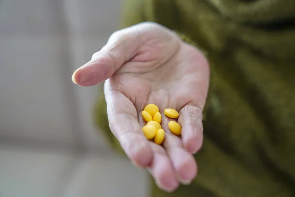 pills in a Senior\'s hands. Painful old age. Caring for the health of the elderly.