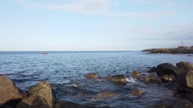 Çakıl taşlarında dalgalar kopuyor. Deniz sörfü. Dalgalar kıyı çakıl taşında ilerliyor. Yaz günü deniz ve sahil tatili konsepti 
