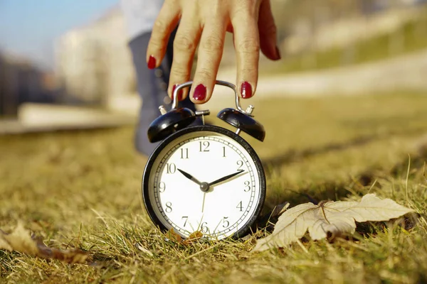 Image of spring Time Change. Summer back concept. Vintage alarm Clock outdoors. alarm clock on green grass