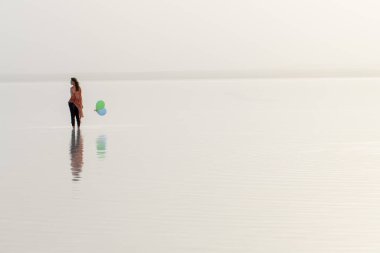Gün batımında denizde yürüyen bir kadın. Plaj Yaz Tatili Seyahat Rahatlama Konsepti 