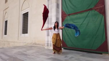 Kahverengi elbiseli göbek dansçısı, takım elbiseli, Doğu dansı yapan bir doğulu. Güzel egzotik göbek dansçısı mavi ve kırmızı şallı kadın 