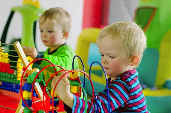 Dzieci bawiące się labiryntem i obfitością. Zabawki Montessori. — Zdjęcie stockowe