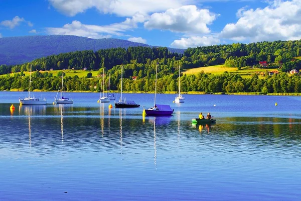 Von der Sonne beleuchtete Boote im Lipno-See mit schöner Landschaft im Hintergrund. — Stockfoto