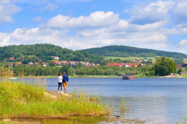 Lipno 'nun romantik manzarası ve Bli Lhota' ya gelen feribotu bekleyen turistler. Lipno Gölü.