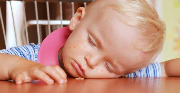 Lindo chico rubio que se queda dormido en la mesa . — Foto de Stock