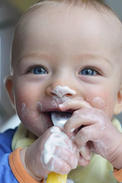 Primer plano retrato de bebé feliz comiendo yohurt — Foto de Stock