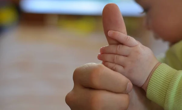 La mano del bebé sosteniendo el pulgar del padre . — Foto de Stock