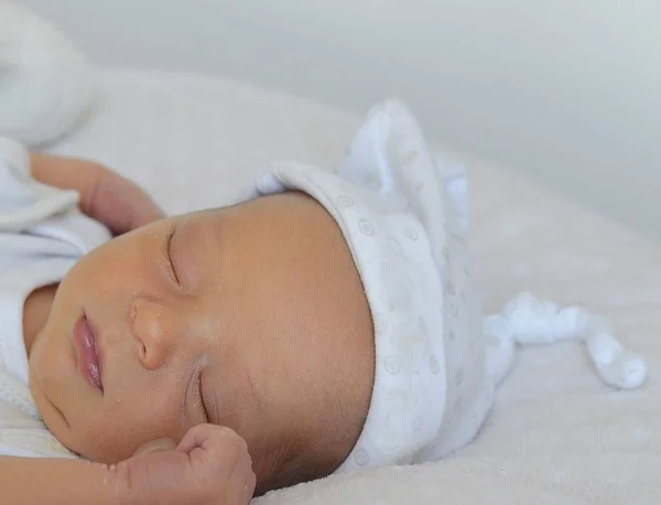 Bebé recién nacido que duerme dulcemente con gorra blanca . — Foto de Stock