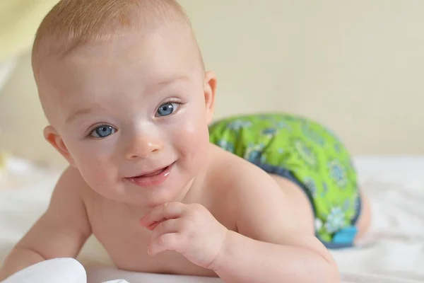 Retrato de un hermoso bebé sonriente en un pañal de tela — Foto de Stock