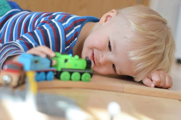 Sonriente niño jugando con una locomotora — Foto de Stock