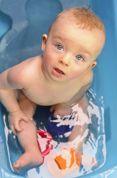 Lindo chico mirando a su padre durante el lavado en una bañera . — Foto de Stock