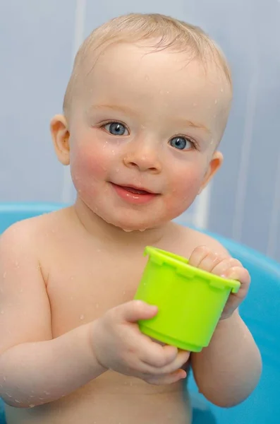 Primer plano retrato de bebé lindo bañándose en un tubo y jugando con tapas de plástico — Foto de Stock