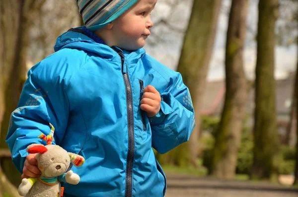 Mały chłopiec spaceruje po parku ze swoim talizmanem szczęśliwie. — Zdjęcie stockowe