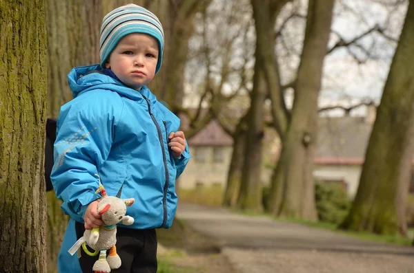 A kisfiú boldogan sétál a parkban a talizmánjával.. — Stock Fotó