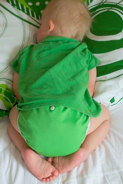 Sleeping cute baby wearing green cloth nappy and green clothes. 로열티 프리 스톡 이미지