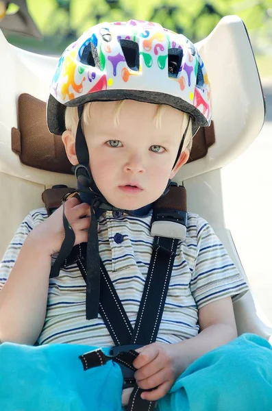 Netter blonder Junge sitzt in einem Kinderfahrradsitz auf Mutters Fahrrad. c — Stockfoto