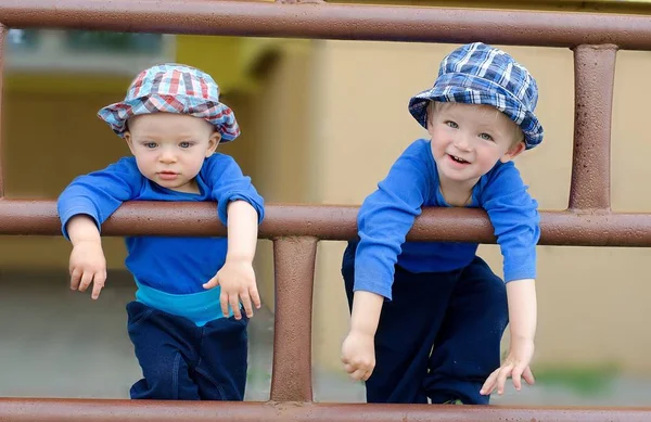 Dos hermanos encantadores, hermanos se basan en barandillas en la ciudad . — Foto de Stock