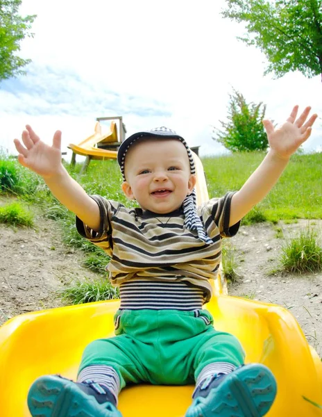Feliz niño deslizándose por una larga diapositiva en la naturaleza . — Foto de Stock