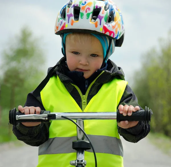 Szczęśliwy chłopiec uczy się jeździć na rowerze po ścieżce rowerowej w przyrodzie. — Zdjęcie stockowe