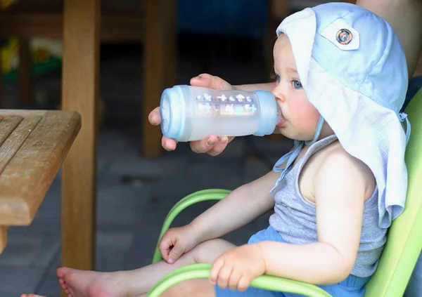 Mothers hand give a bottle of water to drink his baby. 로열티 프리 스톡 사진