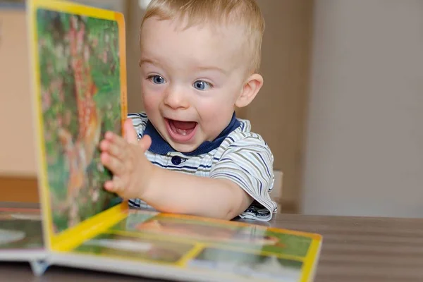 Küçük çocuk, kitabın sayfasını hayvanlarla çeviriyor.. — Stok fotoğraf