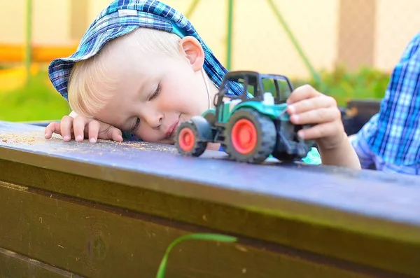 Kleine jongen spelen met een tractor. — Stockfoto