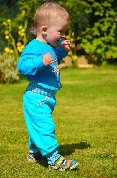 Pierwsze kroki małego chłopca w ogrodzie i słoneczna pogoda. — Zdjęcie stockowe
