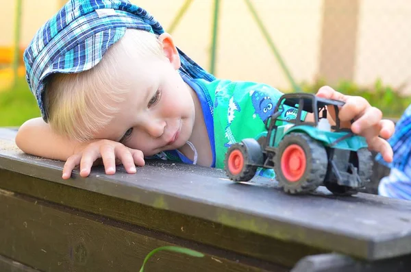 Pequeño niño está jugando con tractor . — Foto de Stock