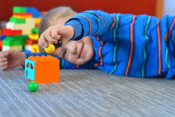 Happy boy playing with marbles.